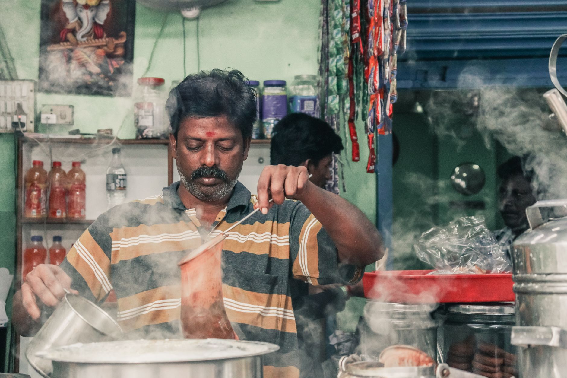 Indian chai-making spread — milk, cardamom, ginger, tea leaves, sugar on a wooden counter