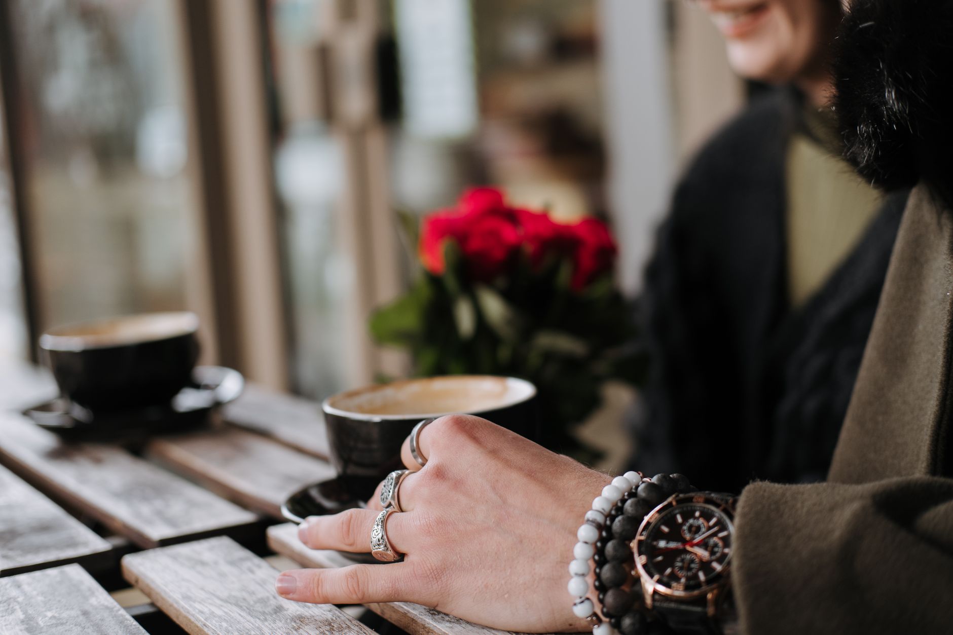 Two friends enjoying decaf cappuccino + herbal tea at a cafe