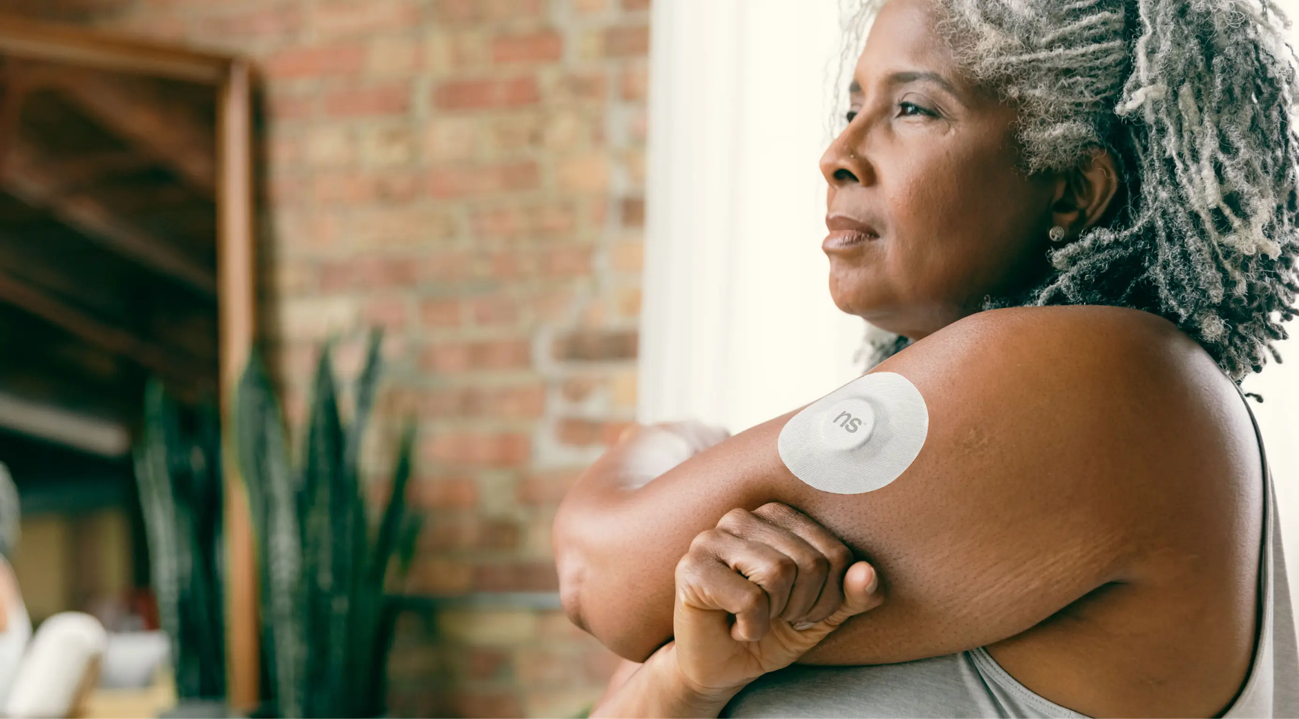 Freestyle Libre continuous glucose monitor on upper arm — close-up