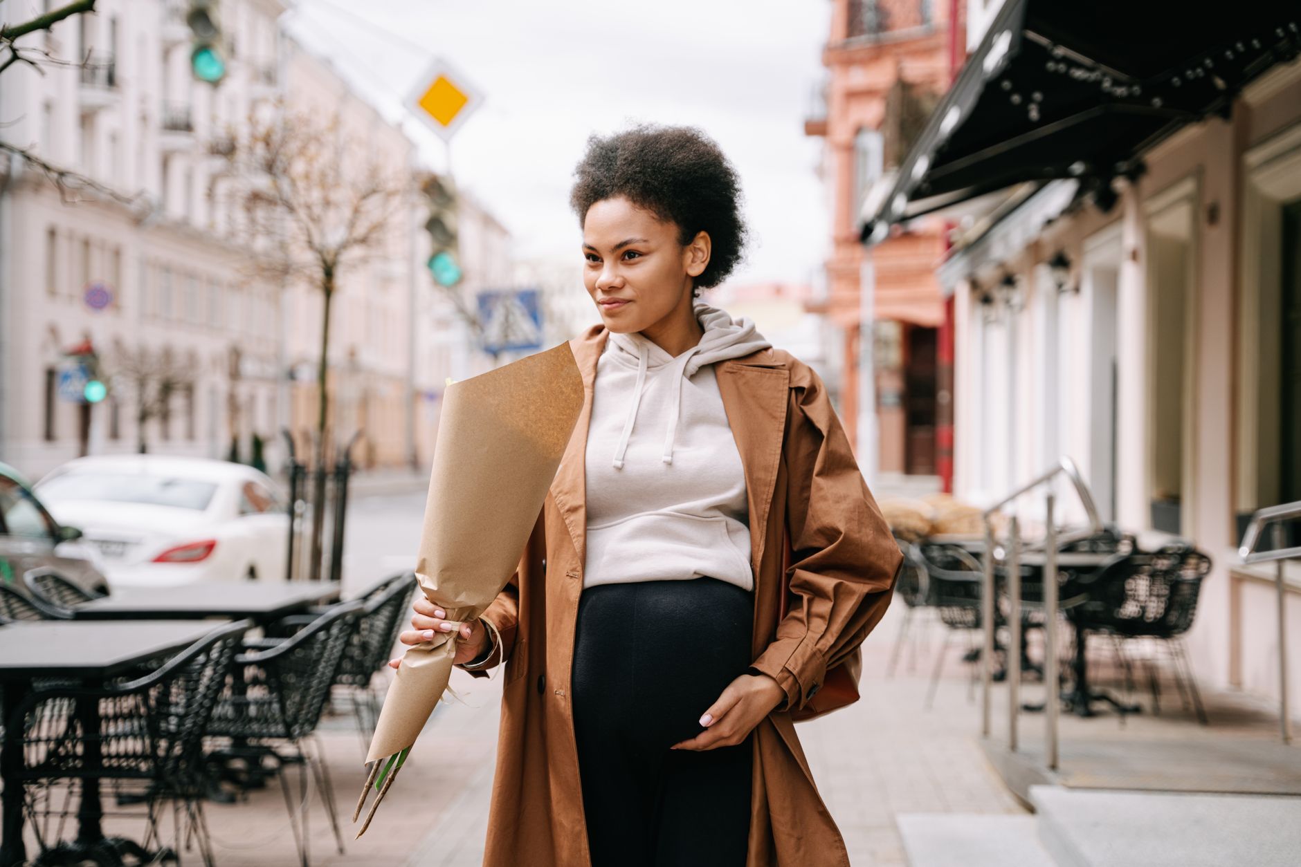 Pregnant woman walking briskly in a sunny park after a meal