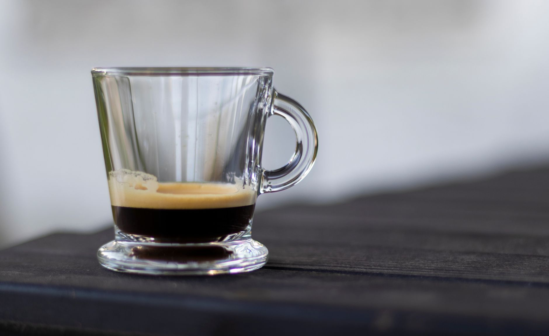 Coffee mug + small glass of wine on a kitchen counter — illustrating moderate consumption while breastfeeding