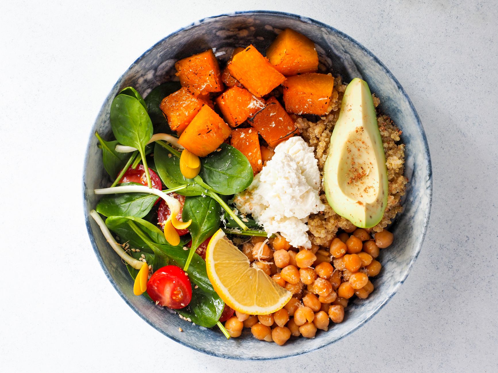 Beautiful Buddha bowl with quinoa, chickpeas, roasted veg, tahini dressing, seeds