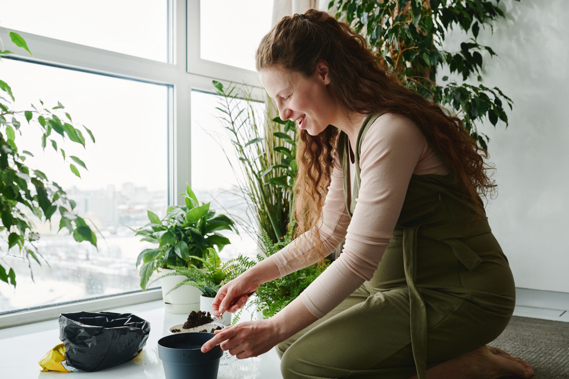Pregnant woman preparing plant-based meal in bright kitchen with vegetables + dal